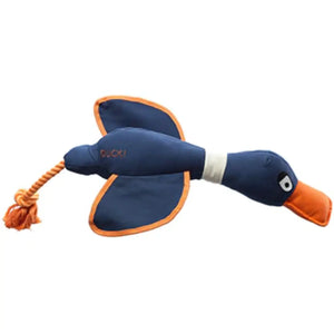A duck-shaped dog toy with a blue body, orange beak and tail, and a white neck. The toy has details such as wings and a rope attached to the tail.